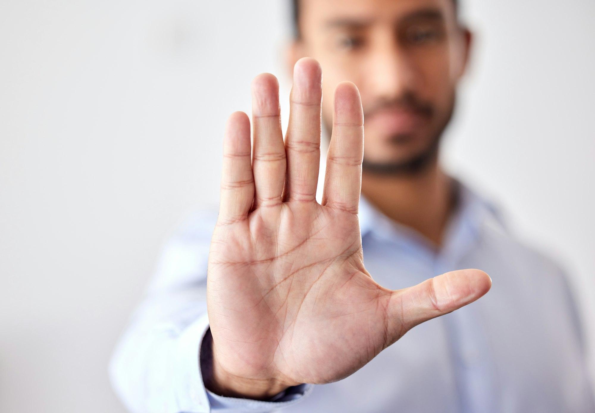 Closeup of the hand of a business man showing stop, saying no or not accepting a deal in an office