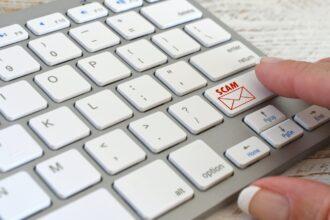 Online Email Scam concept computer keyboard with SCAM email icon symbol about to be opened, no logos