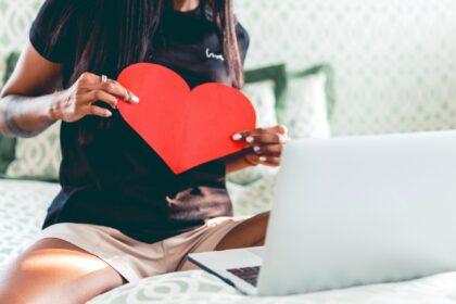 A woman chatting with her lover, holding a heart, love during COVID, long distance relationship