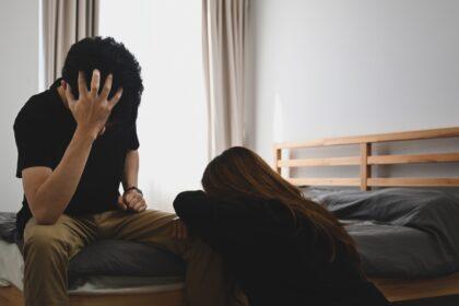 Unhappy couple having conflict while sitting in bedroom. Family relationships problems concept.