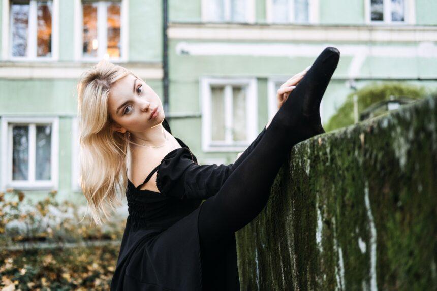 Ballerina Dancing in autumn city street, Modern Ballet Dancer in black dress, Pointe Shoes outdoors.