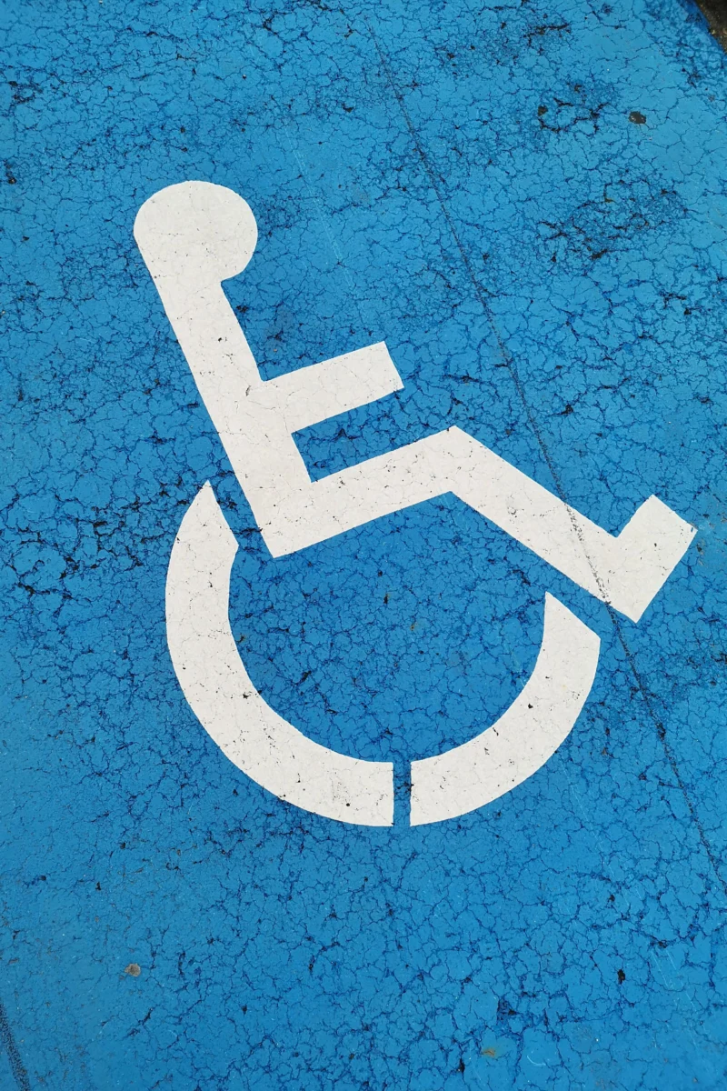 Parking space with wheelchair symbol on blue background for accessibility.