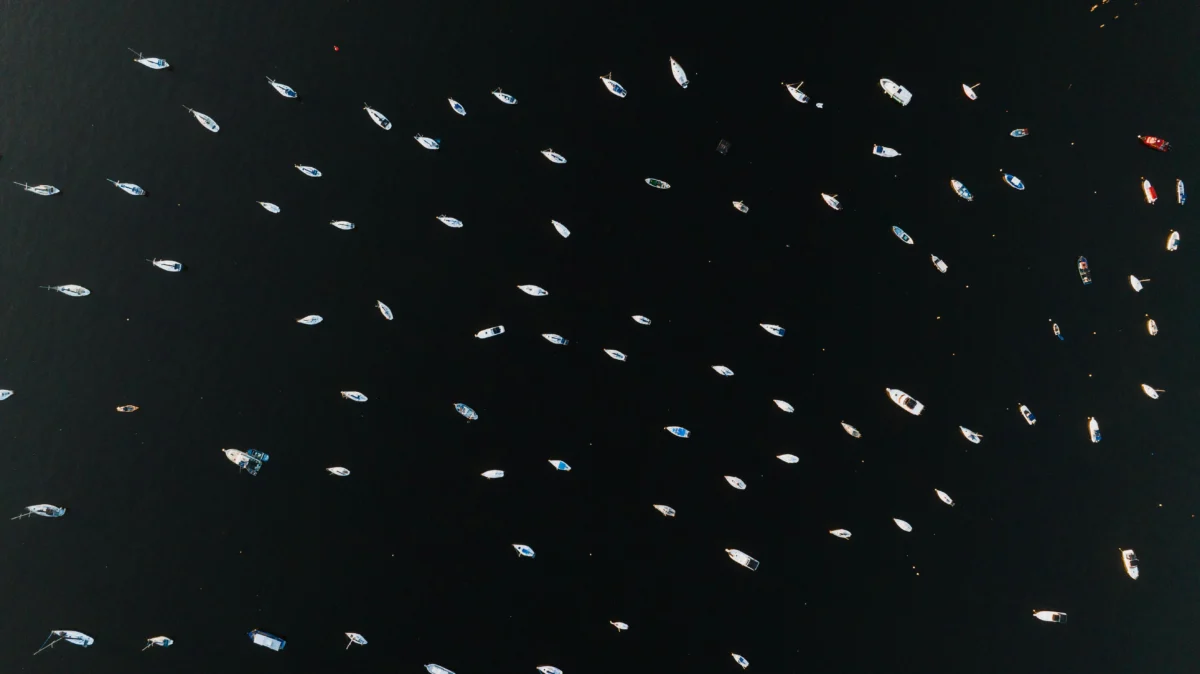 Aerial view of boats scattered across the water in Rio de Janeiro, Brazil, showcasing marine recreation.