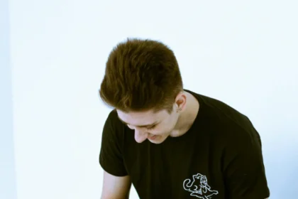 A teenage boy playfully covers a girl's eyes indoors, creating a fun, candid moment.