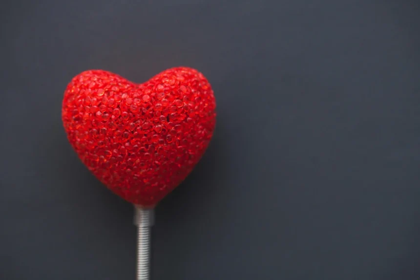 A vibrant red heart on a dark backdrop, symbolizing love and romance.