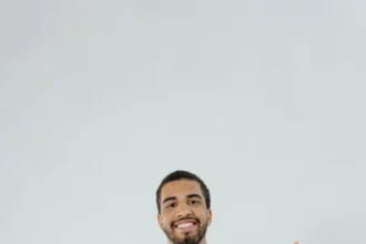 Side profile of a man with braided hair against a white background.