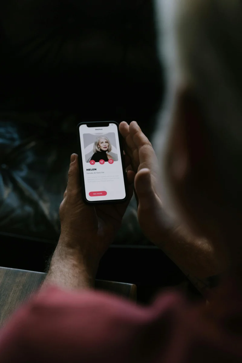 Person using a mobile dating app, highlighting smartphone technology and online connections.