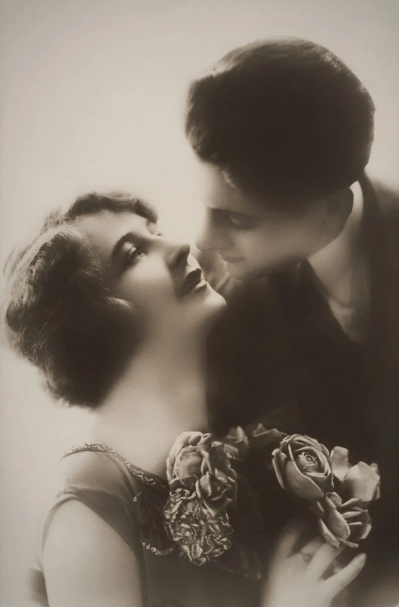Classic black and white vintage portrait of a romantic couple sharing an affectionate moment.