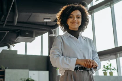 A confident businesswoman smiling in a modern office environment, exuding professionalism and warmth.